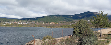 Orilla del embalse de Navacerrada con rocas y montes arbolados