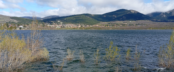 Embalse de Navacerrada con el pueblo y montañas al fondo