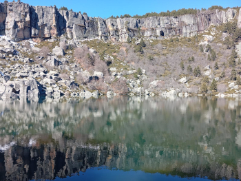 Reflejo del acantilado en las aguas oscuras de la Laguna Negra