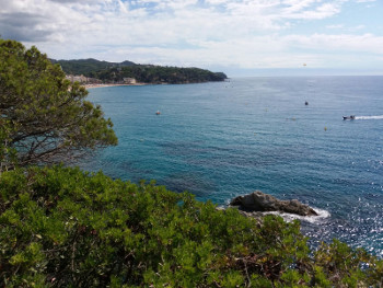 cala de lloret de mar con rocas y agua azul clara